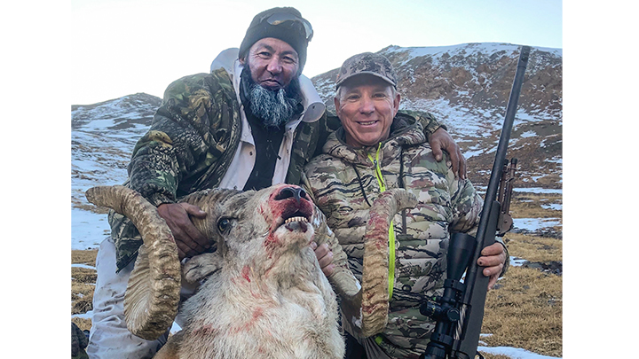 Two hunters with Marco Polo sheep on hunt in Kyrgyzstan