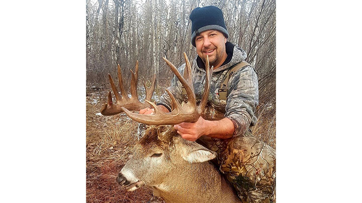 Hunter with massive whitetail buck scoring 189⅞ inches in Manitoba, Canada.