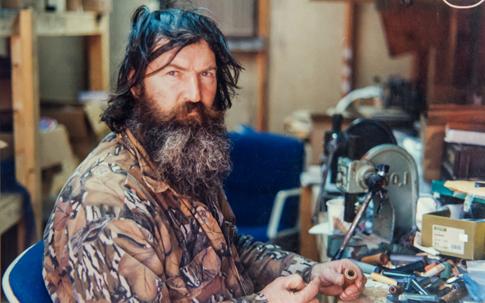 A young Phil Robertson of Duck Commander building a duck call in a wood workshop.