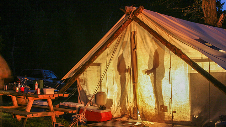 Campers in Wall Tent at Night