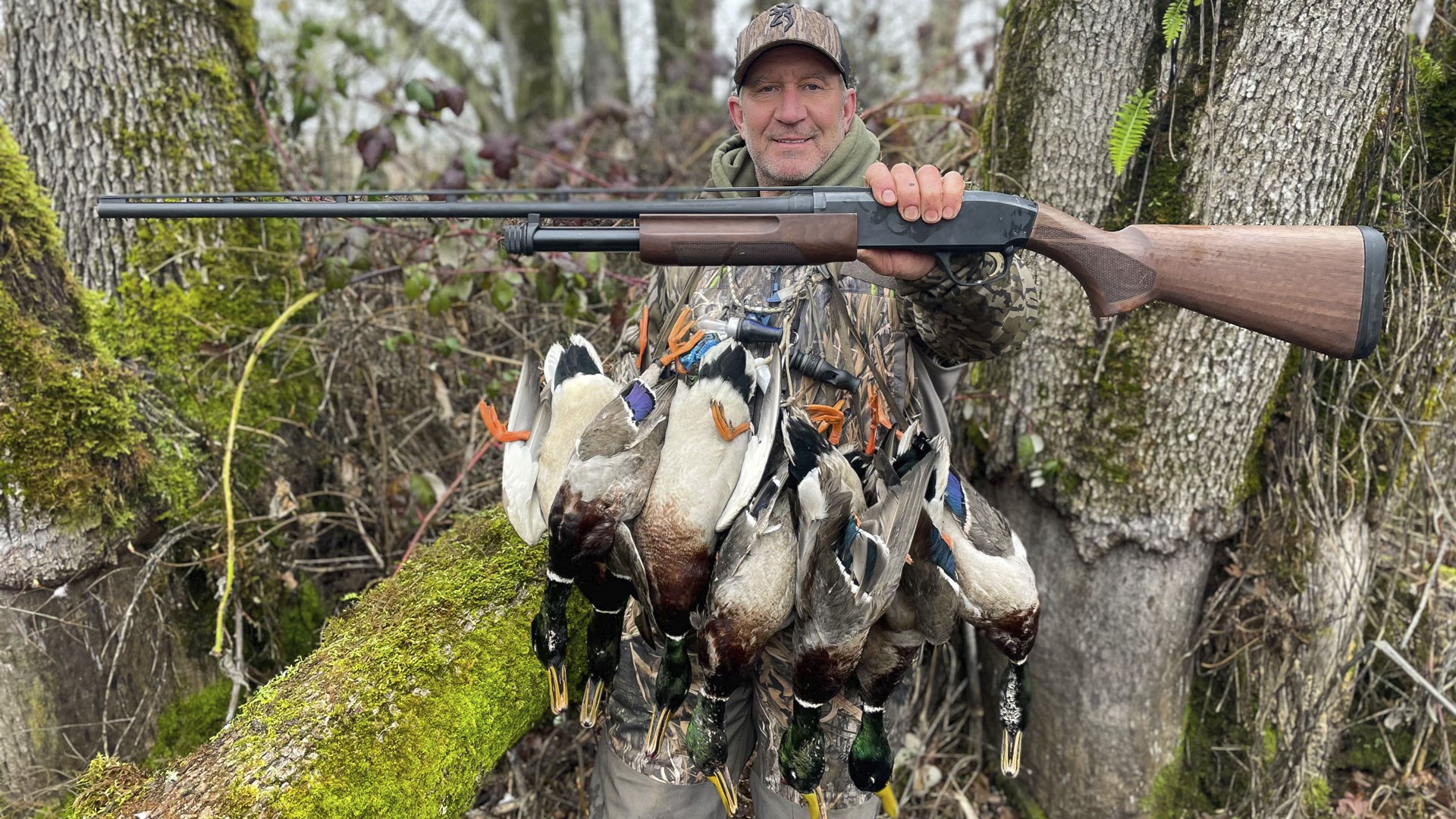 Duck hunter with ducks and shotgun