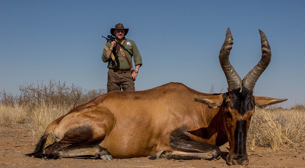 Male hunter with hartebeest in Namibia.