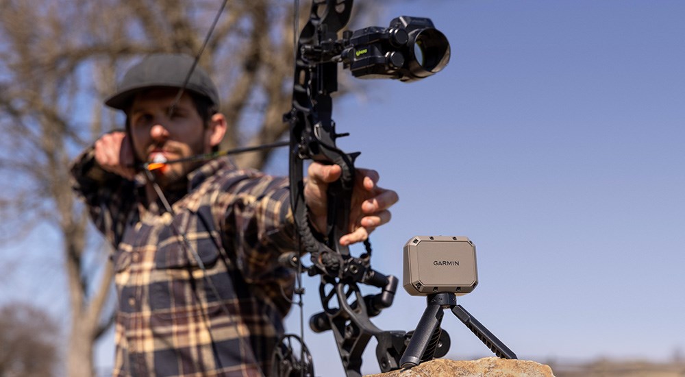 Bow hunter using Garmin Xero C1 Pro chronograph to measure arrow speed.