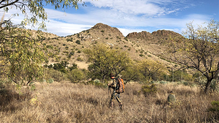 Hunter hiking through valley