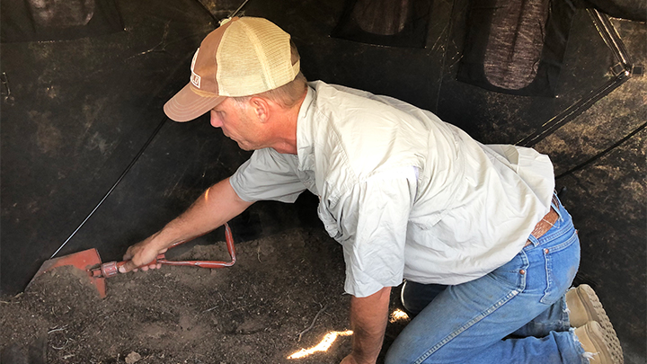 Bowhunter staking ground blind out