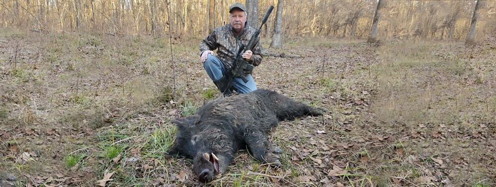 Bill Wilson, founder and President of Wilson Combat kneeling on ground.