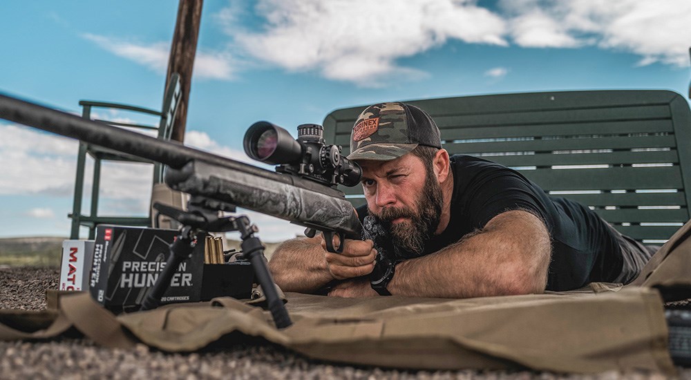 Male shooting rifle prone on shooting range.