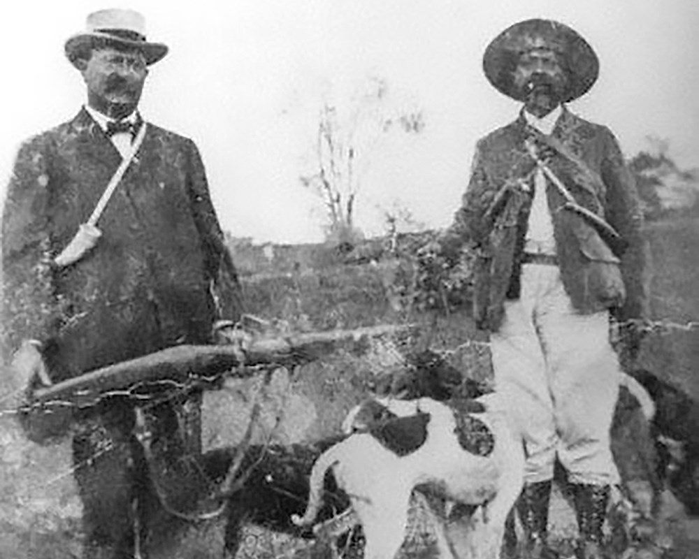Two male hunters with dog.