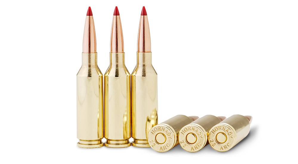 Three Hornady 22 ARC ammunition loads standing with three laying flat on right side on white background.