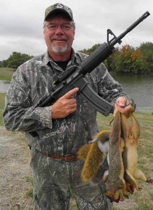 Mike Roux with rifle holding fox squirrels