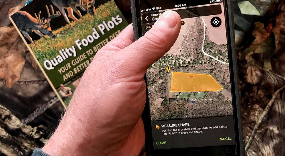 Male using HuntStand hunting app to map food plot on hunting property.