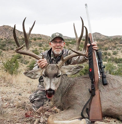 Hunter with mule deer buck in Texas