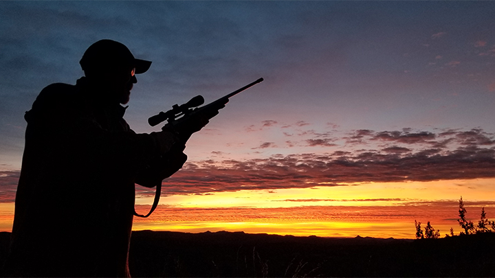 Hunter silhouette in desert sunrise