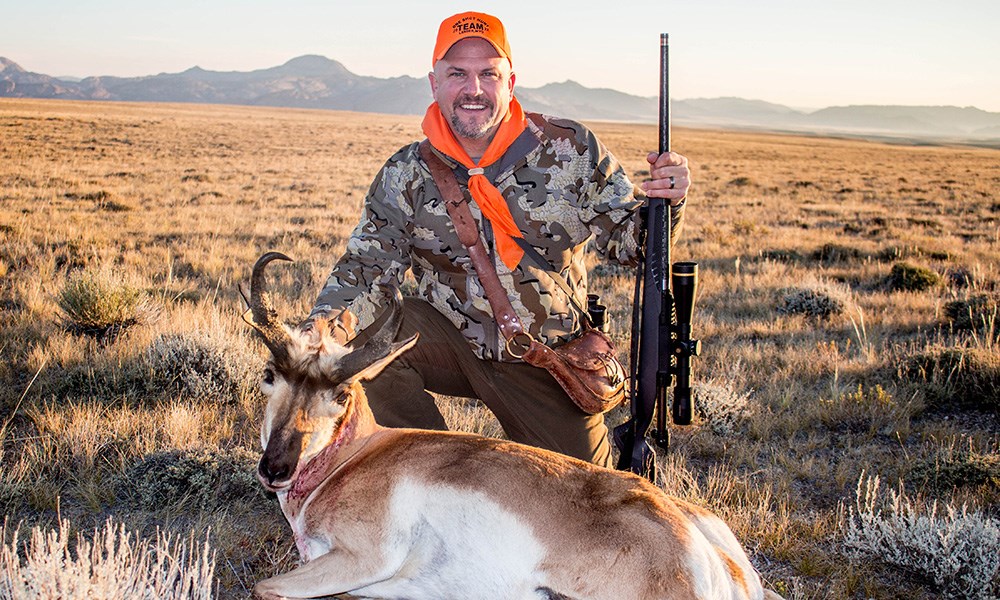 Male hunter with pronghorn in Wyoming plains.