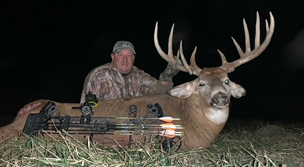 Male hunter with whitetail buck killed in central Illinois with compound bow.