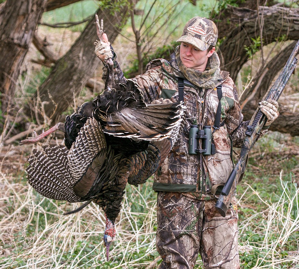 Male hunter holding turkey.