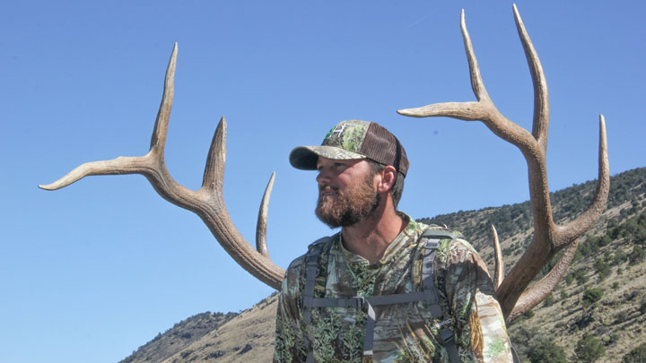Hunter with elk antlers on his back