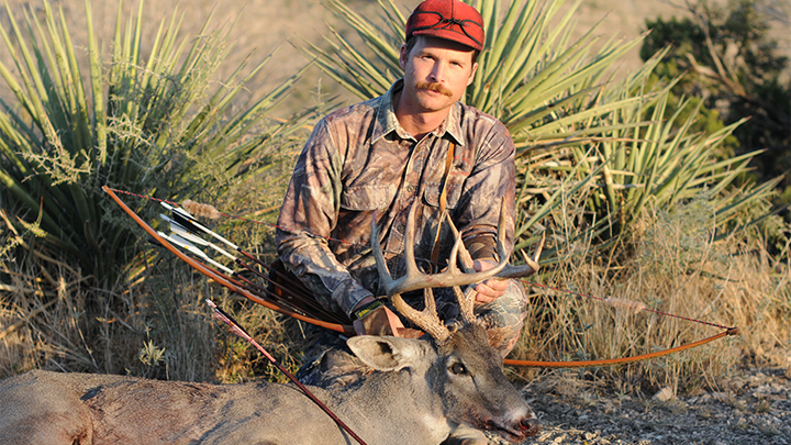 Hunter with buck taken with Traditional recurve bow