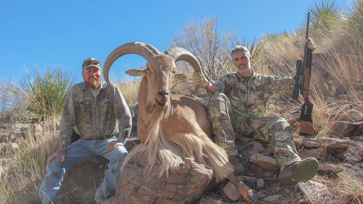 A hunger in camo and a guide in blue jeans pose with a goat taken by a .30-06 Springfield