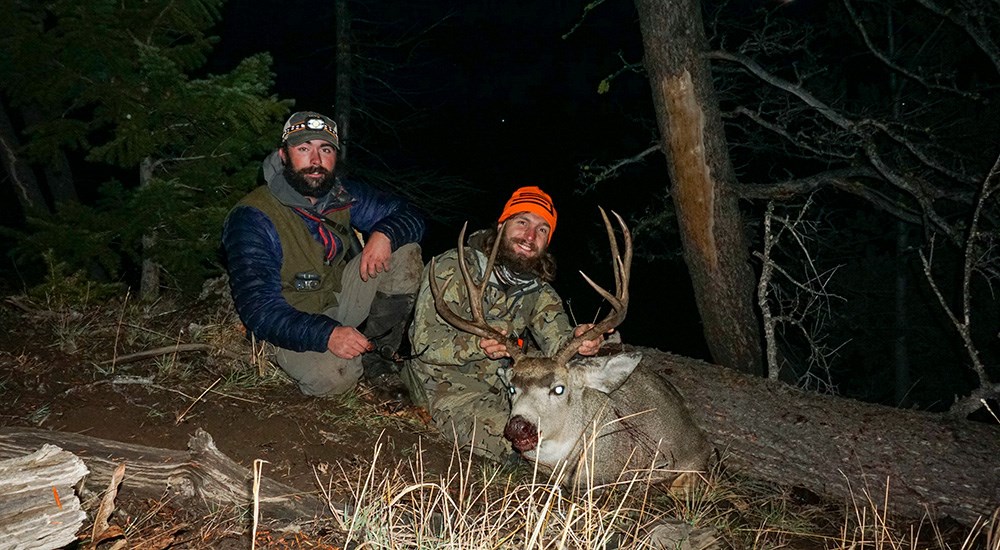 Hunter and hunting guide posing with mule deer buck.