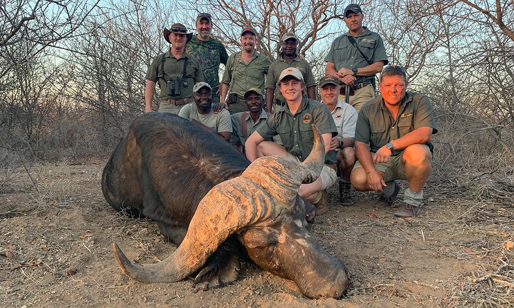 South African Professional Hunters and male clients posing with Cape buffalo.