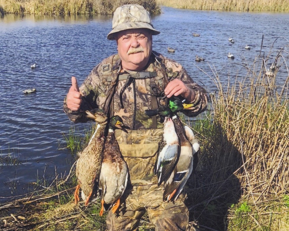Veteran waterfowl hunter with mallard ducks