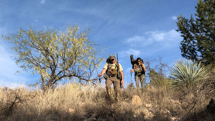 Hunters descending a ridgeline