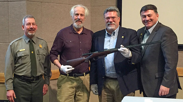 Denali National Park superintendent Don Striker, left, Charlie Sheldon, grandson of Charles Sheldon, executive vice president of conservation for the Boone &amp; Crockett Club Tim Brady and John Hendrix celebrate the presentation of the rifle.