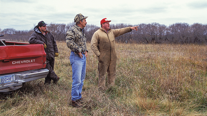 Hunters pointing out game in field