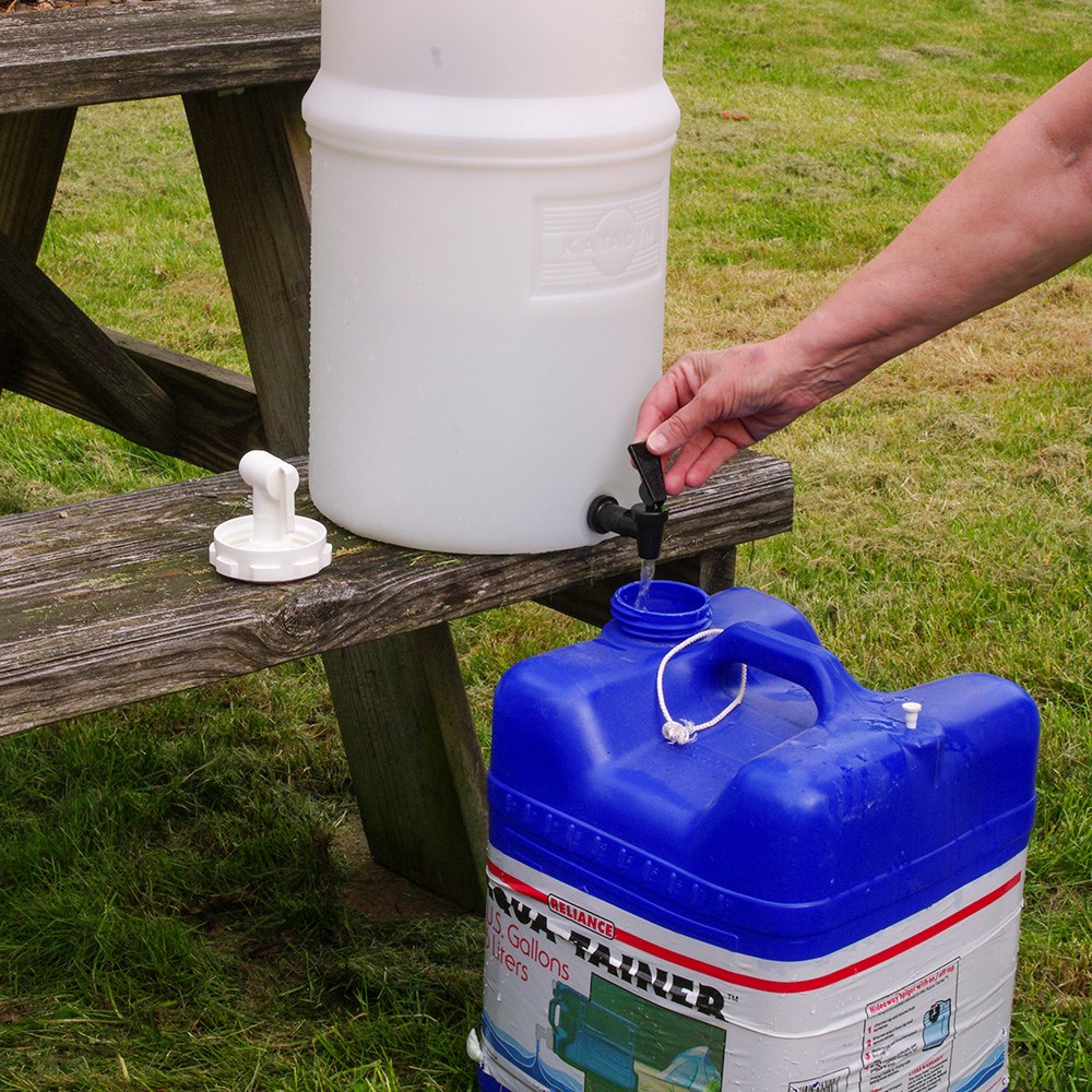 Large tank of treated drinking water on wooden picnic table.