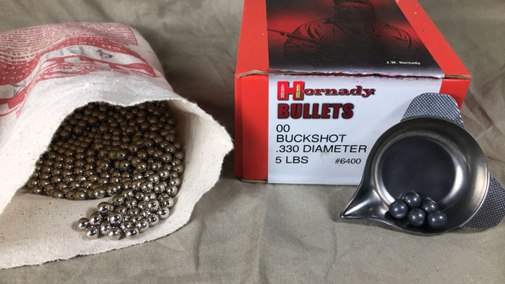 Hornady shot in a bag and measuring cup, in front of its box.