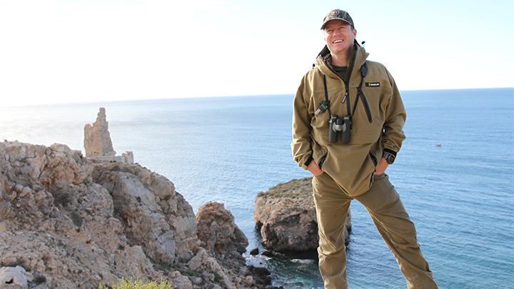 Hunter standing on cliffside near Mediterranean Sea