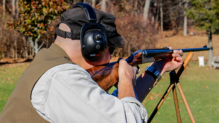 Hunter shooting Heym 450/400 off three-legged shooting sticks