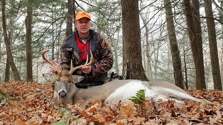 Hunter with whitetail buck in New York