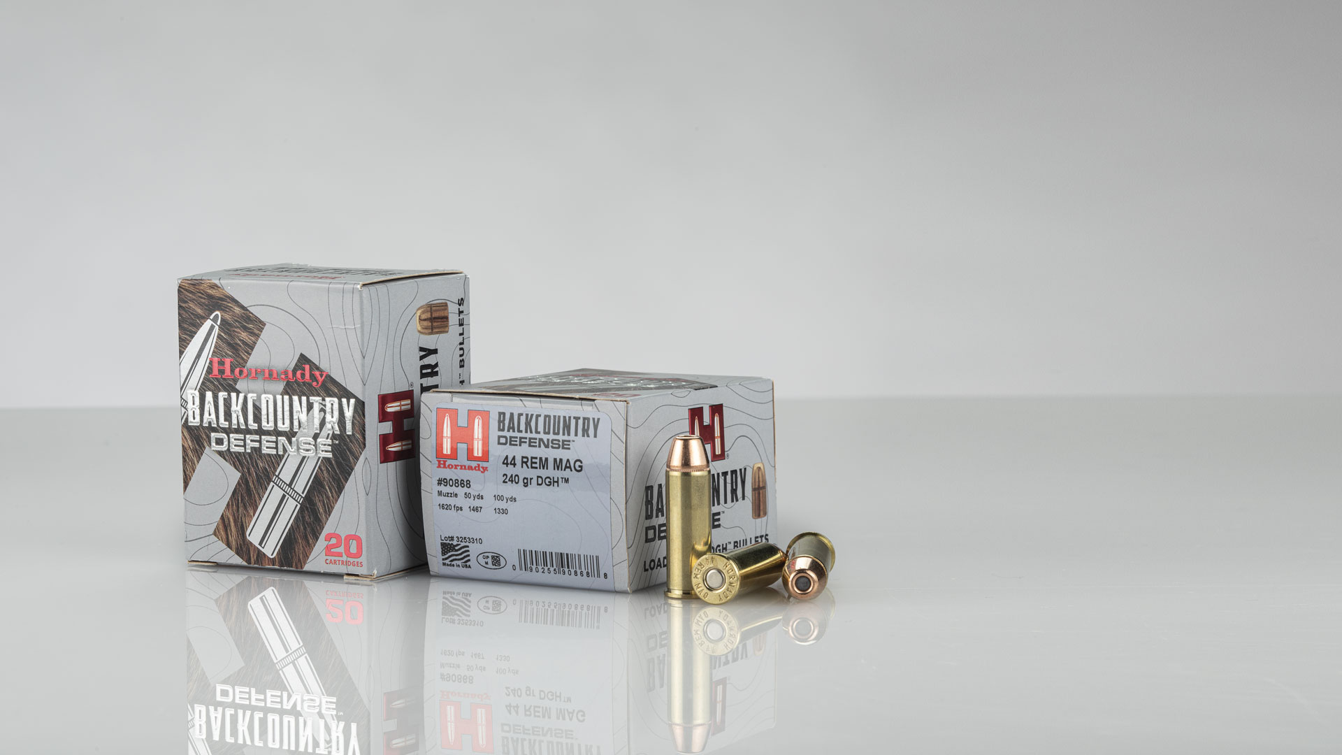 Hornady Backcountry Defense ammunition boxes bullets arranged on white gray table with clear shadow below packaging