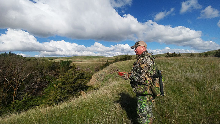 Turkey Hunter Using Box Call at Top of Ridge