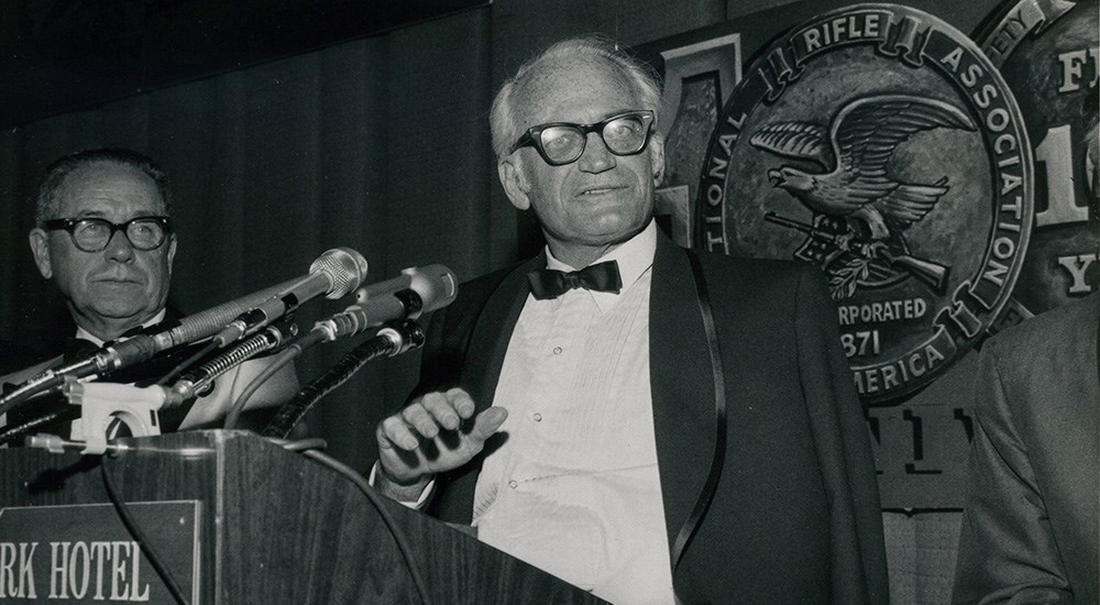 Sen. Barry Goldwater speaking at podium at National Rifle Association event in 1970s.
