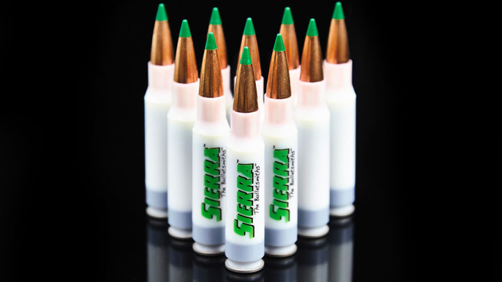 10 rounds of True Velocity, with white cases and green tips, arranged in a triangle on a shiny black surface.