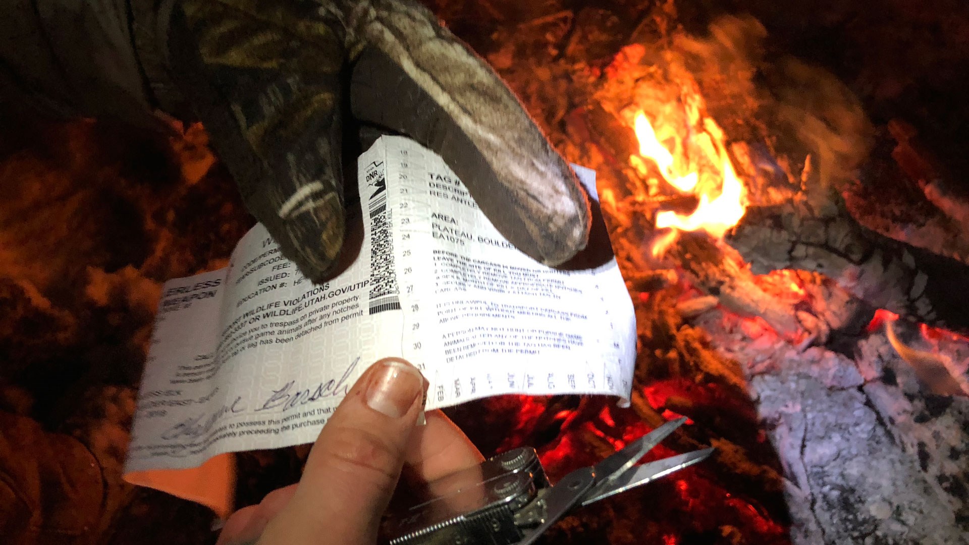 Notching a tag by the fire.