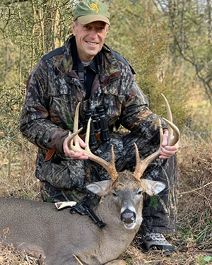 Deer hunter with whitetail buck