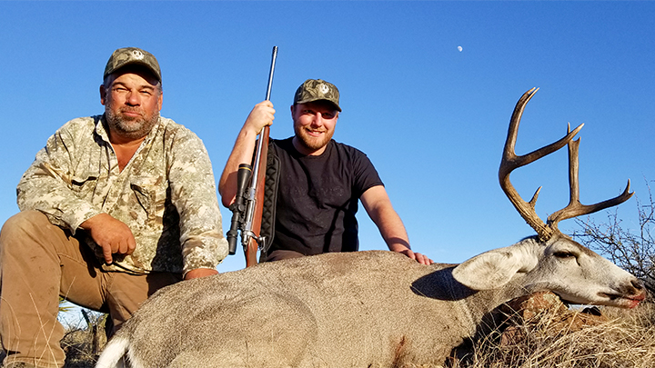 Hunter and guide with mule deer buck