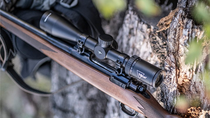 Trijicon Huron Hunting Riflescope Mounted on Rifle Against Tree