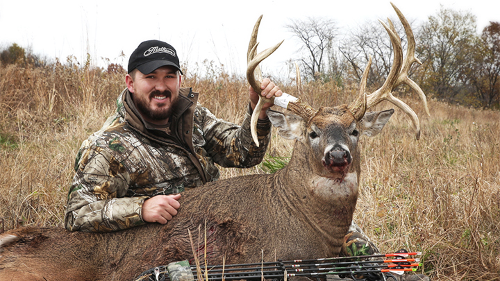 Hunter with whitetail buck in Iowa