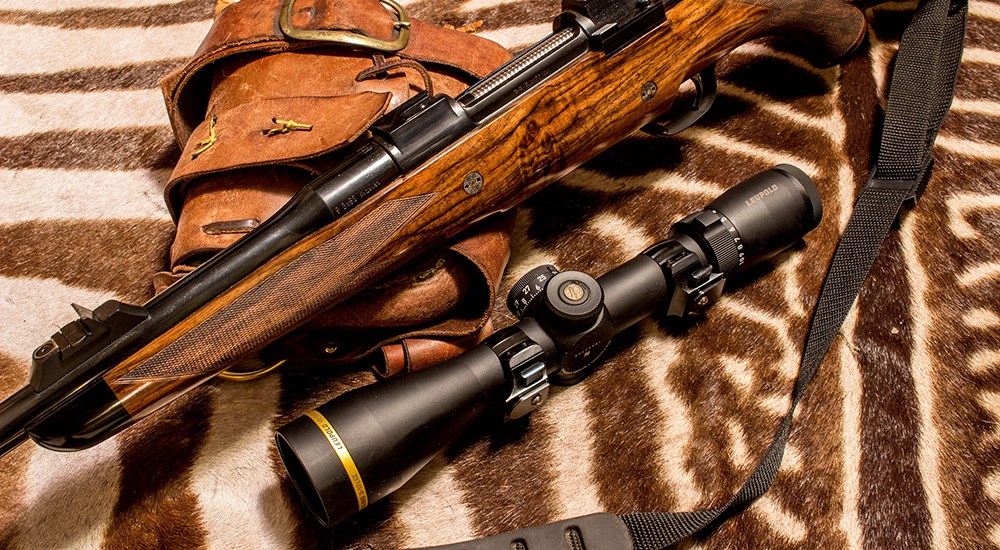 Bolt action rifle with Leupold rifle scope on zebra rug.