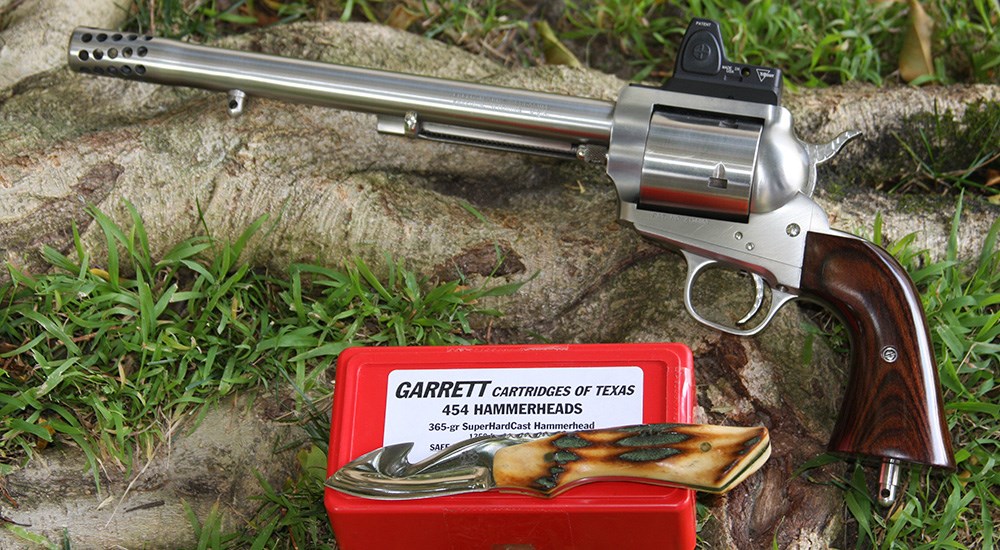 Freedom arms revolver laying next to Garret Cartridges of Texas .454 hammerheads bullets.