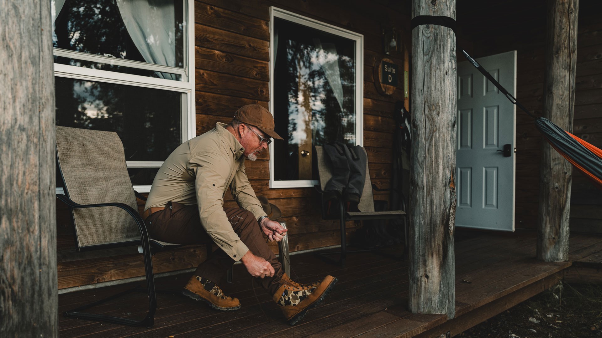 Man on porch putting on ball and buck x Danner light