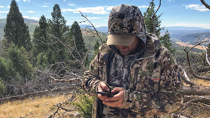 Hunter using Hunting App in mountains