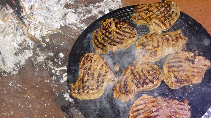 Steaks cooking on a grill