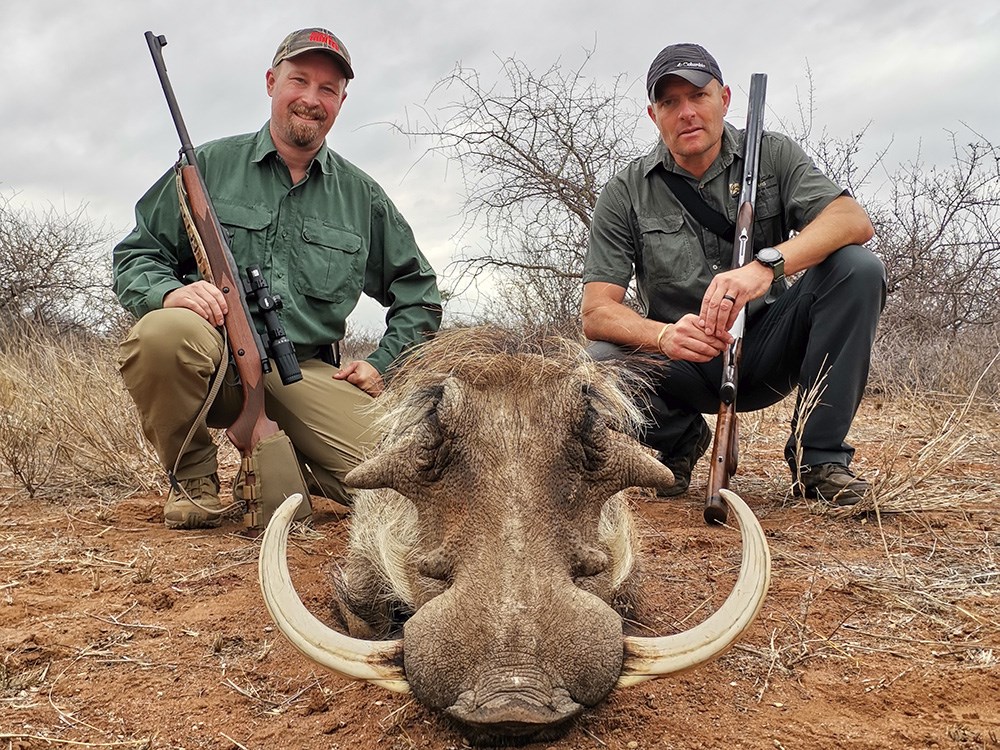 Two hunters with large warthog in South Africa.