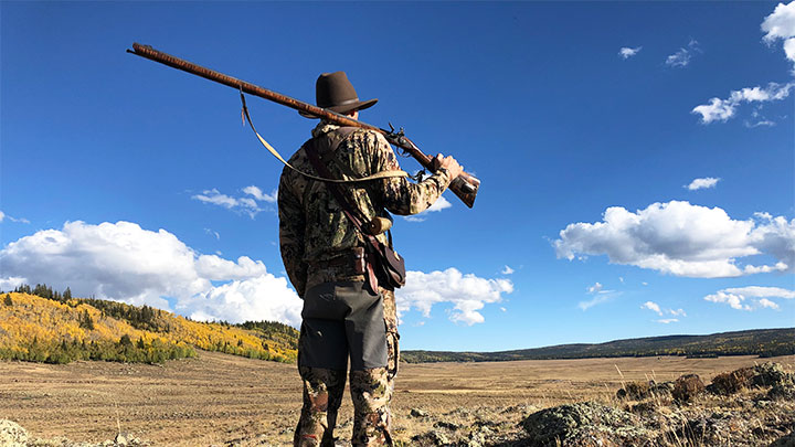 Hunter with Rifle Over Shoulder in Canyon